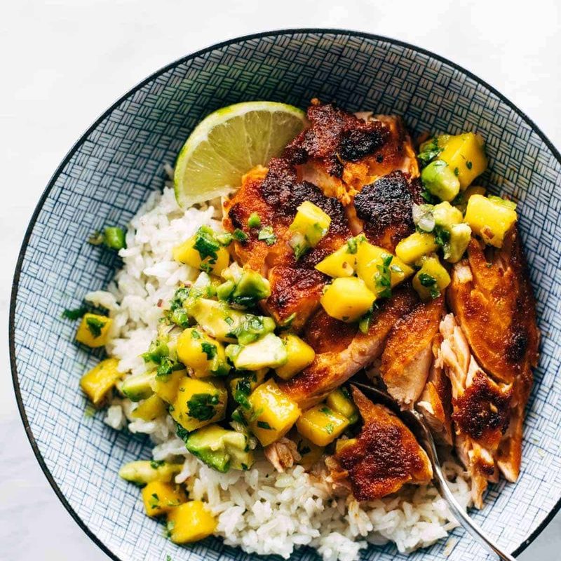 BBQ salmon in a bowl with mango salsa and rice.