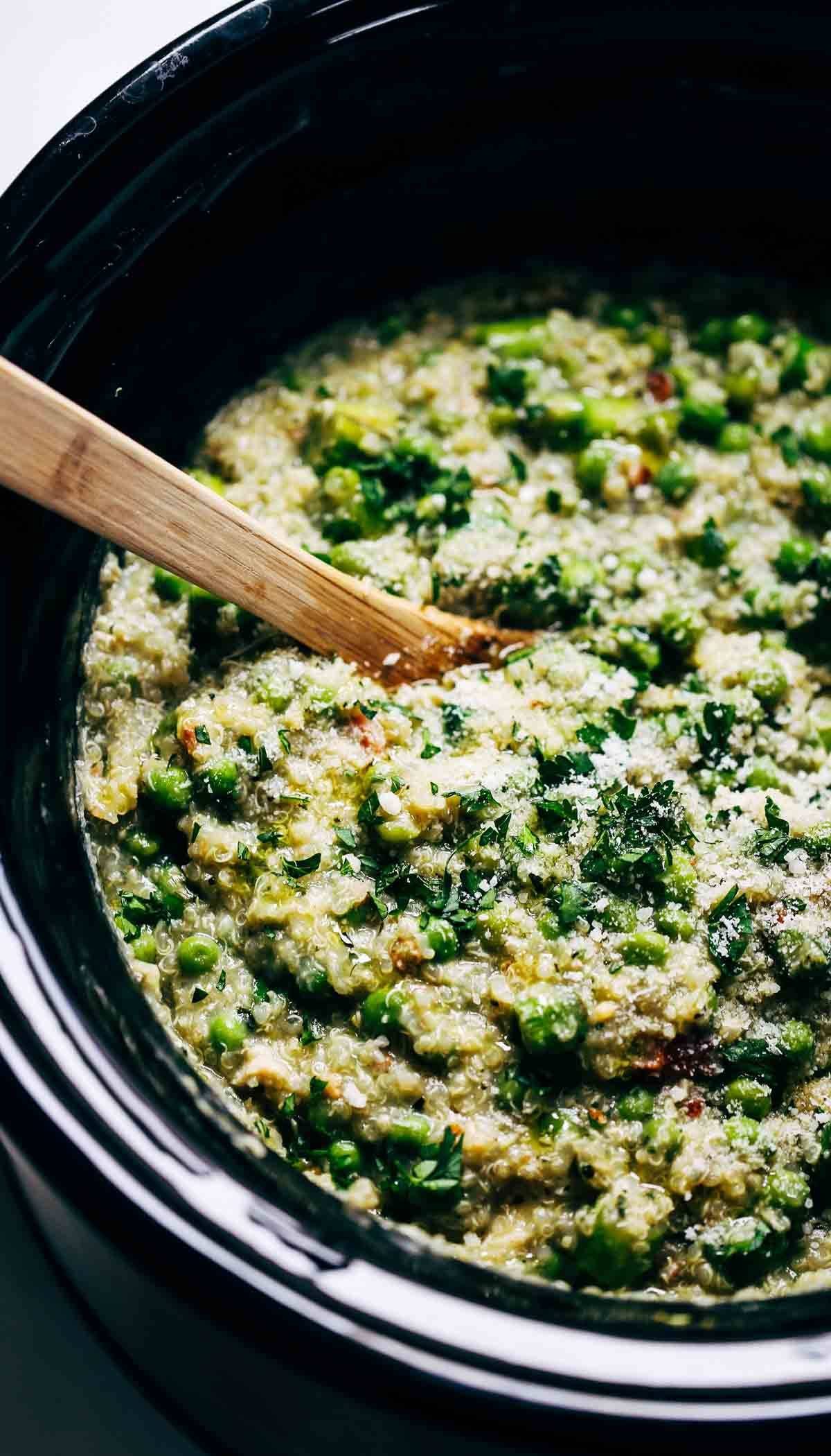 Crockpot Quinoa Chicken Primavera with a wooden spoon.