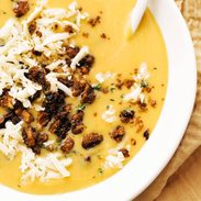 Pumpkin soup in a bowl with walnut crispies and a spoon!