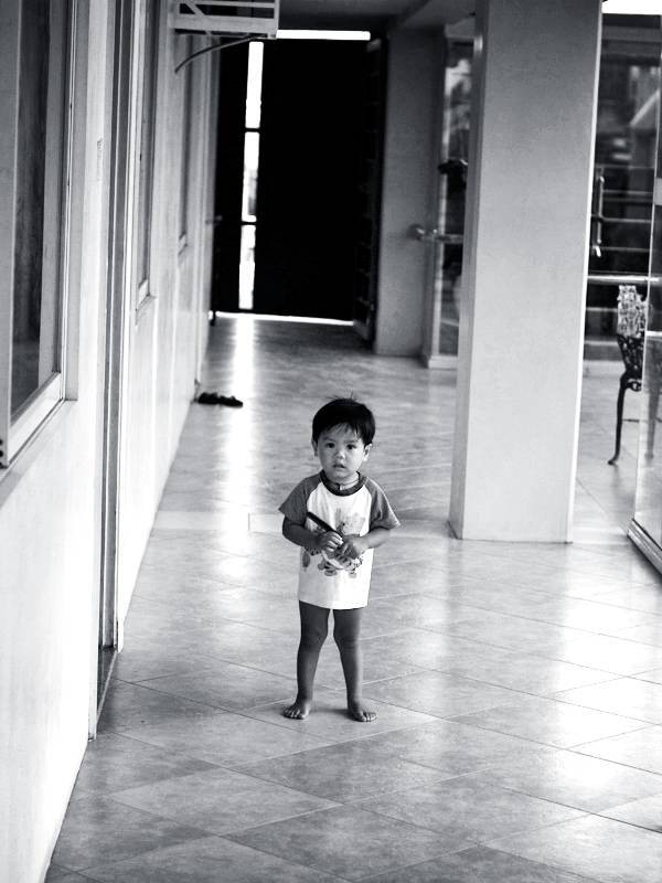 Boy standing in a hallway.