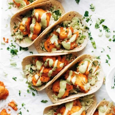 Buffalo cauliflower tacos drizzled with creamy avocado sauce.