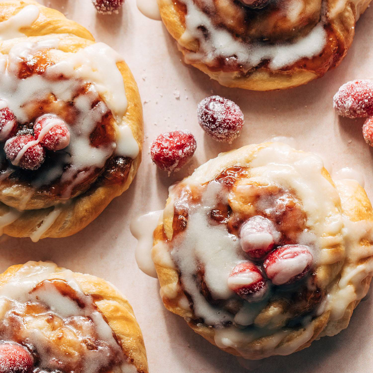 Cream cheese danishes with a glaze and sugared cranberries.
