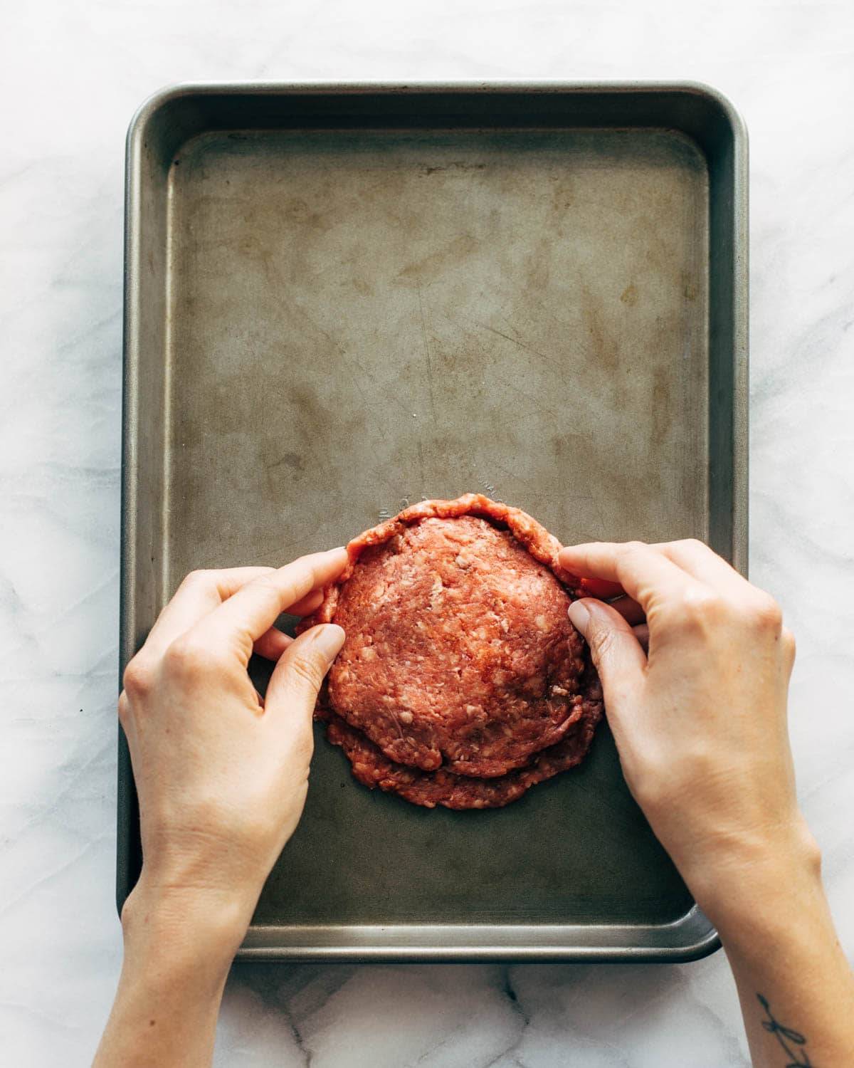 Burger patties with cheese before grilling.