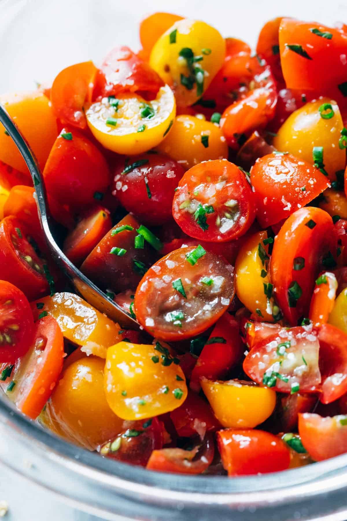 Marinated tomatoes with a spoon.