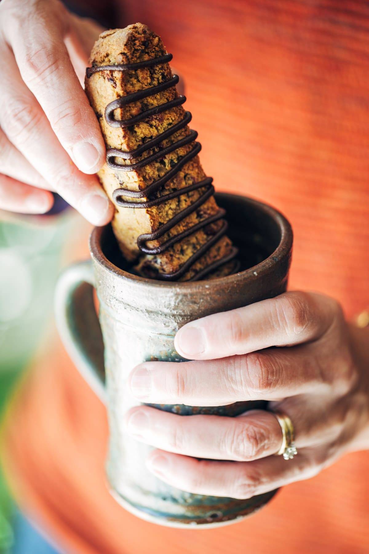 Cranberry Dark Chocolate Biscotti dunking in a mug.